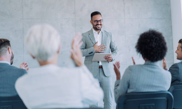 istock Businesspeople applauding during a seminar in conference hall. 1368665452