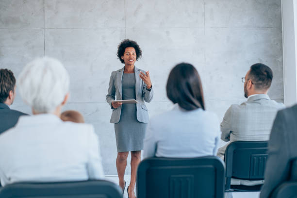 bizneswoman dając prezentację z kolegami. - female business confidence meeting zdjęcia i obrazy z banku zdjęć