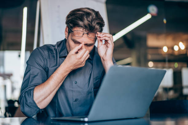 istock Stressed businessman having headache while working on laptop in the office. 1368665529