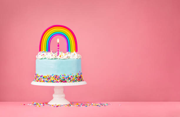 istock Blue Birthday Cake with Rainbow topper on Pink 1368666312