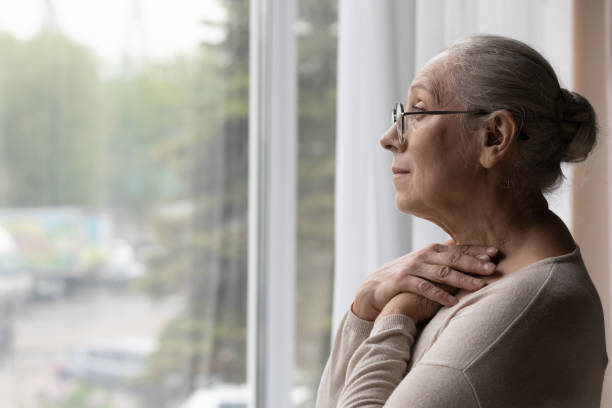 Depressed elderly mature woman in eyewear looking in distance. Side view frustrated depressed elderly mature retired woman in eyewear looking in distance out of window, suffering from loneliness or personal problems at home, recollecting memories or mourning. widow stock pictures, royalty-free photos & images
