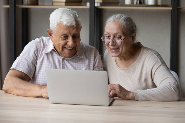istock Loving smiling elderly couple using laptop at home. 1368666486