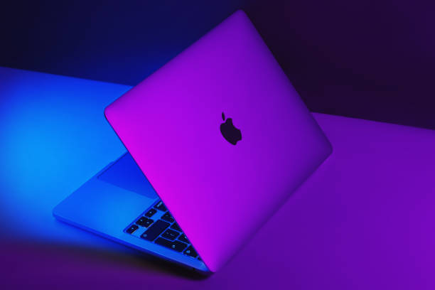 カラフルな光の背景を持つアップルブランドm1モデルのmacbookのプロ。 - macbook ストックフォトと画像