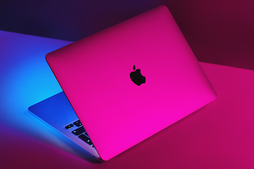Izmir, Turkey - January 10, 2022: Half opened Apple Brand M1 Model Macbook pro laptop computer with purple and blue colored lights