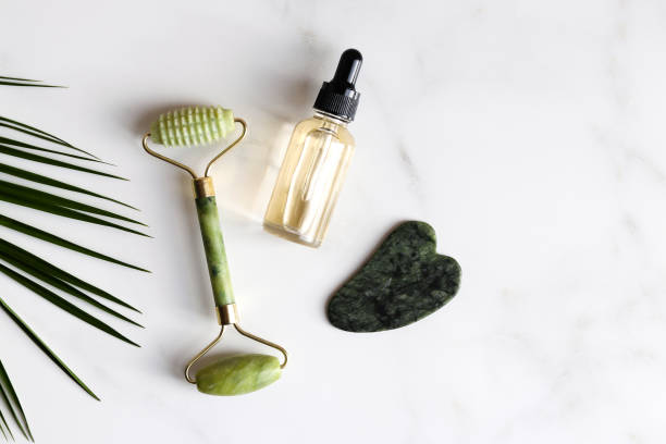 istock Special devices for Gua Sha. Jade face roller, stone for massage and essential oil on marble table.Traditional Chinese facial massage. Beauty and health care concept. Top view 1368669726