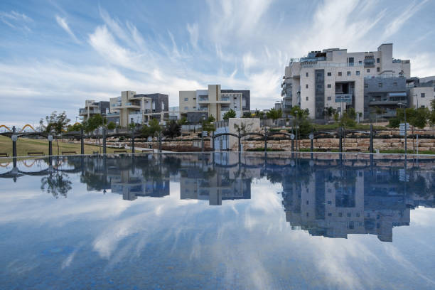 Artificial shallow pond in a public park in Be'er-Sheva. Reflection of dramatic cloudy sky on water.