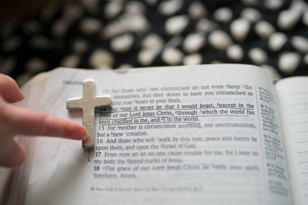 Child's hand pointing to cross on Bible page with underlined verse in Nashville, Tennessee, United States