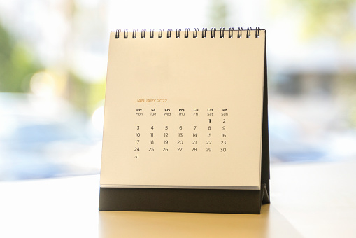 Close up of a 2022 monthly calendar with metal spiral-bound, standing on the table
