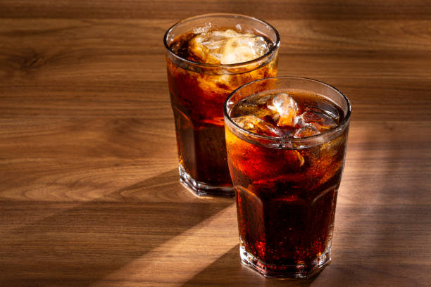 istock Soda glasses with ice cubes on wooden table. 1368680262