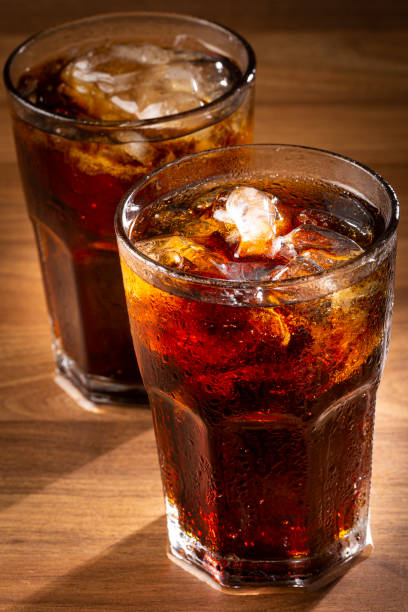 istock Soda glasses with ice cubes on wooden table. 1368680274