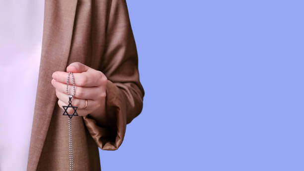 femme enseignante tenant le symbole religieux juif étoile à six branches sur fond bleu studio, bannière en gros plan - judaism photos et images de collection