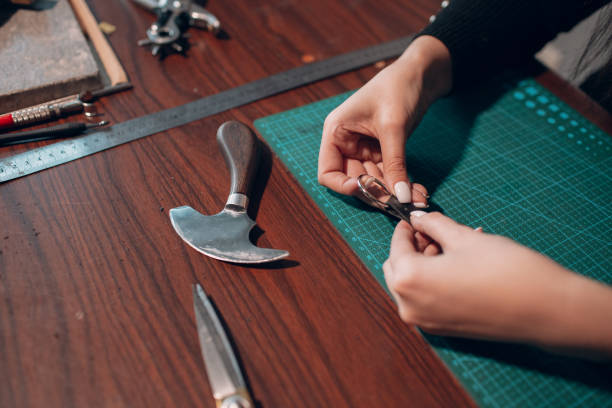 istock Tanner woman making leather goods on workshop. Working process of leather craftsman 1368681117