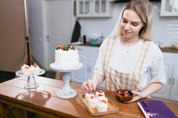 istock Pastry chef confectioner young caucasian woman with cake on kitchen table. 1368681142