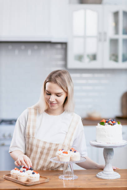 istock Pastry chef confectioner young caucasian woman with cake on kitchen table. 1368681143