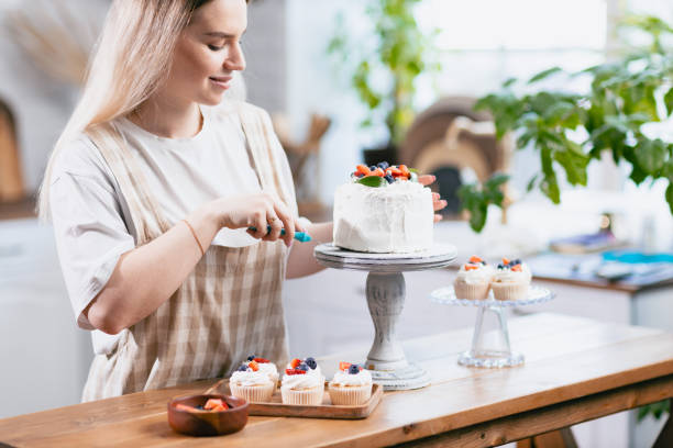 istock Pastry chef confectioner young caucasian woman with cake on kitchen table. 1368681145