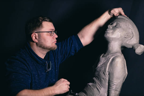 istock Man sculptor creates sculpt bust clay human woman sculpture. Statue craft creation workshop 1368681195