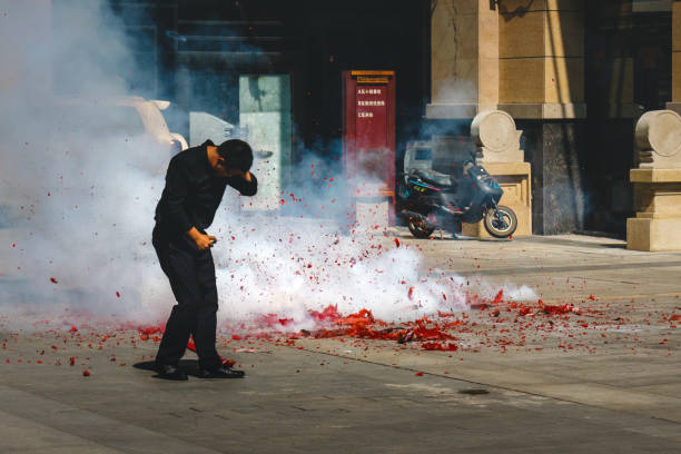 An Asian man light huge amount of firecrackers trying to escape stock photo