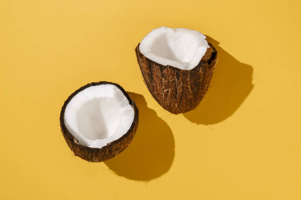 istock Two halves of coconut on a bright yellow background. 1368706596