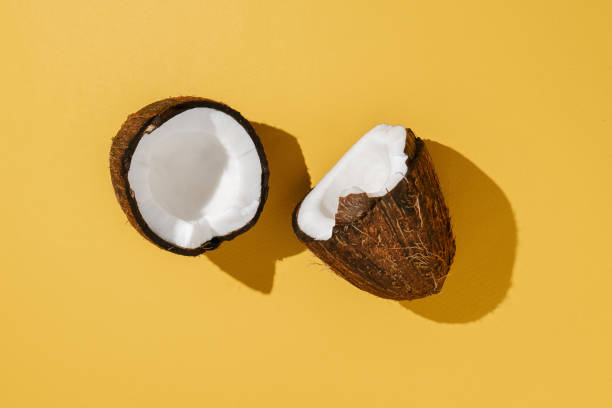 istock Two halves of coconut on a bright yellow background. 1368706609