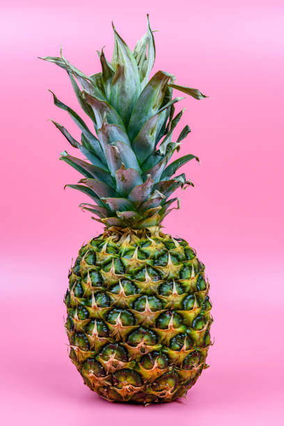 istock Whole ripe pineapple on the pink background 1368710297