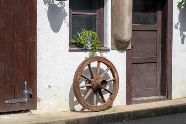 Antique vintage wooden carriage wheel hanging on the wall. Home rustic decorations. stock photo