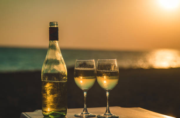 istock Wine glasses at sunset on the beach. Selective focus. 1368717251