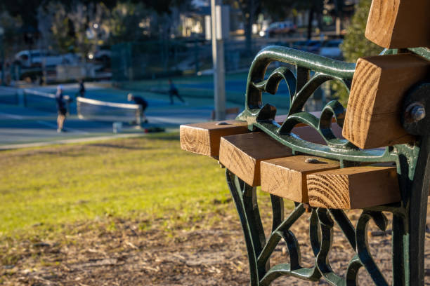 Bench next to pickleball courts in public park stock photo