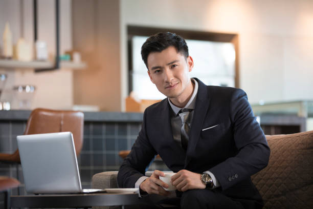 Successful Chinese businessman use computers to work in coffee shops stock photo