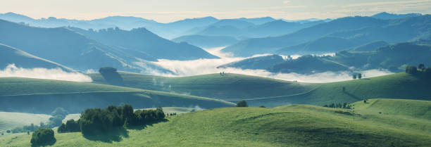 istock Mountains and hills in morning light, fog in the valley, panoramic 1368726111