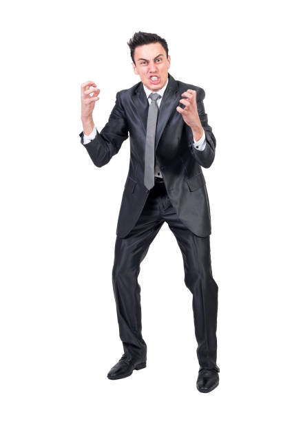 Portrait of businessman in punch stance against black background at night.