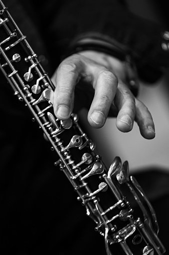 The hand of a musician playing the clarinet in black and white