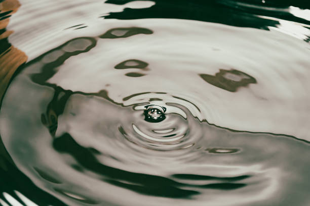 istock Circles on dark shiny dirty water with a bubble in the middle. Liquid surface background banner in shades of rust. 1368732128