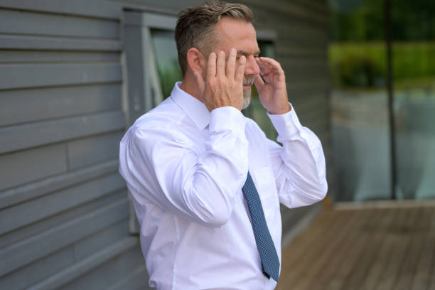 Distressed or anxiius senior man raising his hands