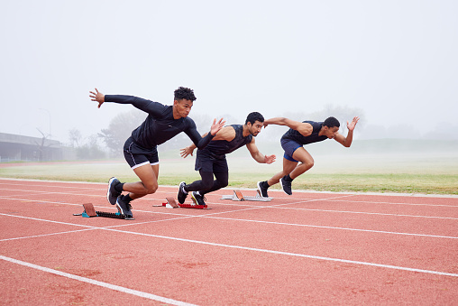 Group of athletes at the track ready to run