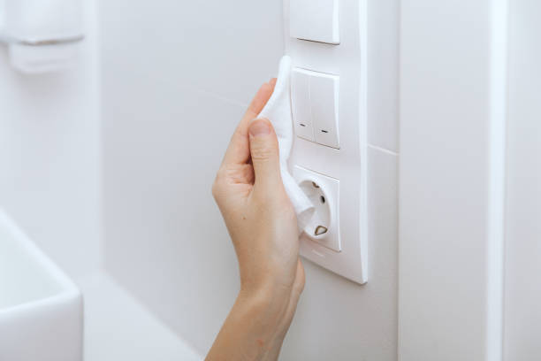 istock Cleaning switches and sockets with a microfiber cloth. Woman hand using wet wipe for cleaning home room door link. Sanitize surfaces prevention in hospital and public spaces against corona virus 1368734849