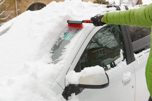 冬に彼の車を掃除する男 - snow car window ice scraper ストックフォトと画像