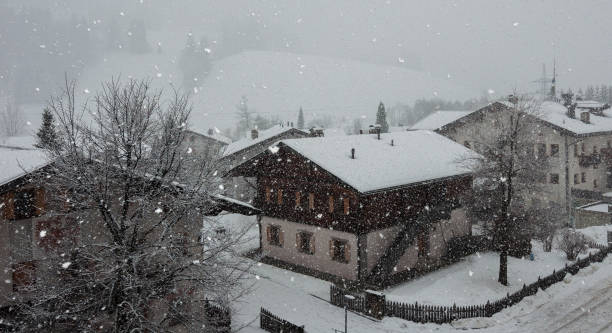 starker schneefall zwischen tiroler hütten in den bergen - blizzard house storm snow stock-fotos und bilder