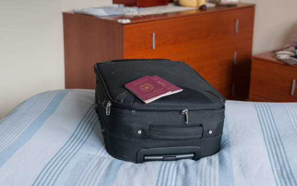 suitcase and passports ready to go suitcase on the bed and passports valigia stock pictures, royalty-free photos & images