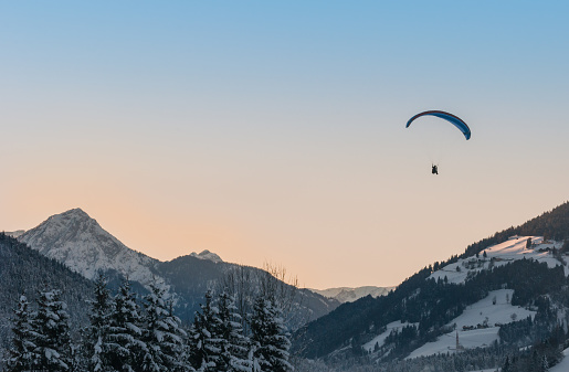 paragliding sunset over the snowy mountains