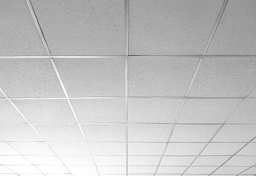 Fondo y textura de las baldosas de techo blancas con barra en T con una buena gradación de luz en ángulo bajo y vista en perspectiva photo