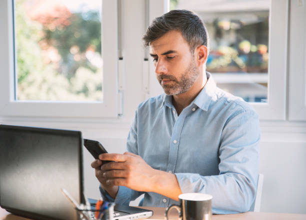 istock Businessman working from home using smartphone and  laptop 1368742445