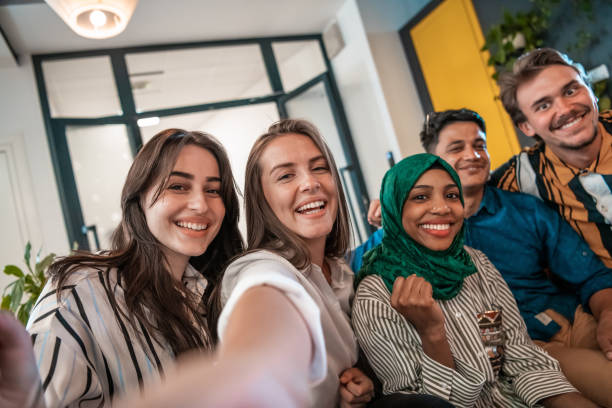 Group of business people during break from the work taking selfie picture while enjoying free time in relaxation area at modern open plan startup office. Selective focus Group of business people during a break from the work taking selfie picture while enjoying free time in relaxation area at modern open plan startup office. Selective focus. High-quality photo Public Sector stock pictures, royalty-free photos & images