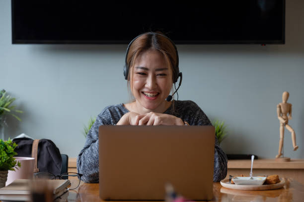 istock Happy asian woman freelancer wearing headset, communicating with client via video computer call. Millennial pleasant professional female tutor giving online language class 1368744054