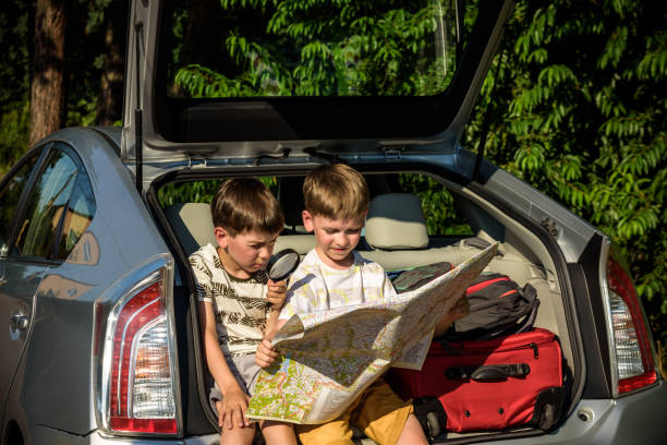 istock Two cute boys sitting in a car trunk before going on vacations w 1368745859
