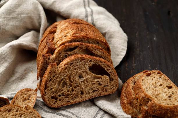 istock Traditional sourdough bread cut into slices on a rustic wooden background 1368748616