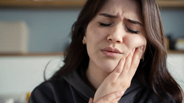 Woman suffering toothache at home stock photo