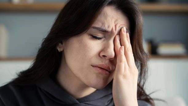 istock Young woman with headache in home interior 1368751597