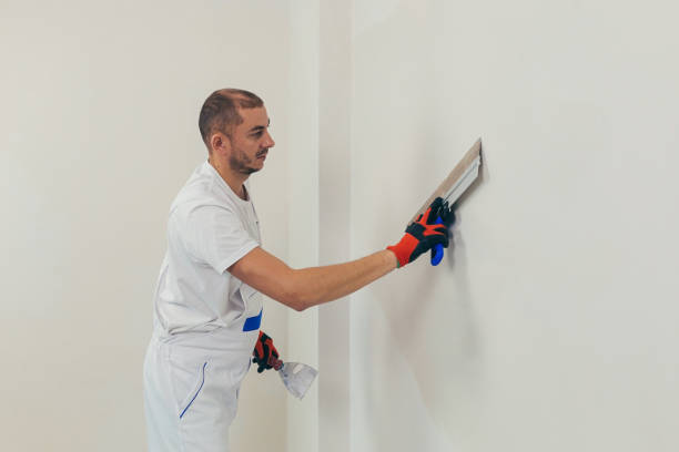 istock A man worker plasters the wall with a spatula and applies a cement mix solution. The repairman lays the plaster on the drywall 1368751629