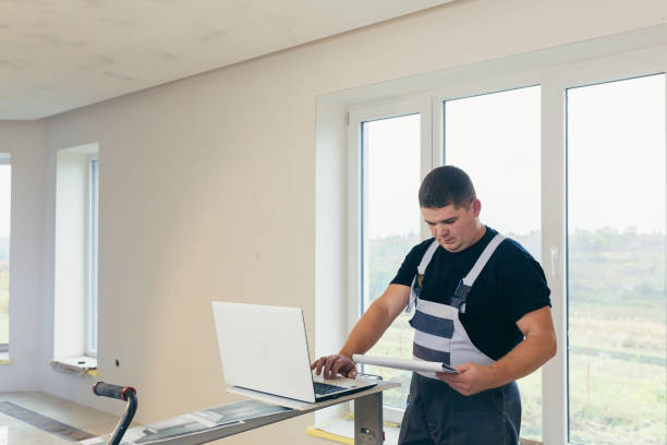 istock The master man, the builder considers the project, uses a laptop, for construction purposes. Studies the work plan 1368751699
