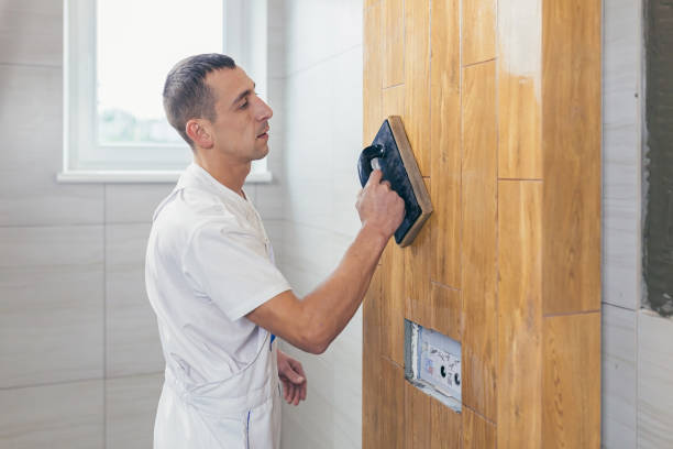istock Builder applying grouting on shower tiles in bathroom. Grouting ceramic tiles process of filling the seams of tiled. Grouting ceramic tiles process of filling the seams of tiled 1368751707